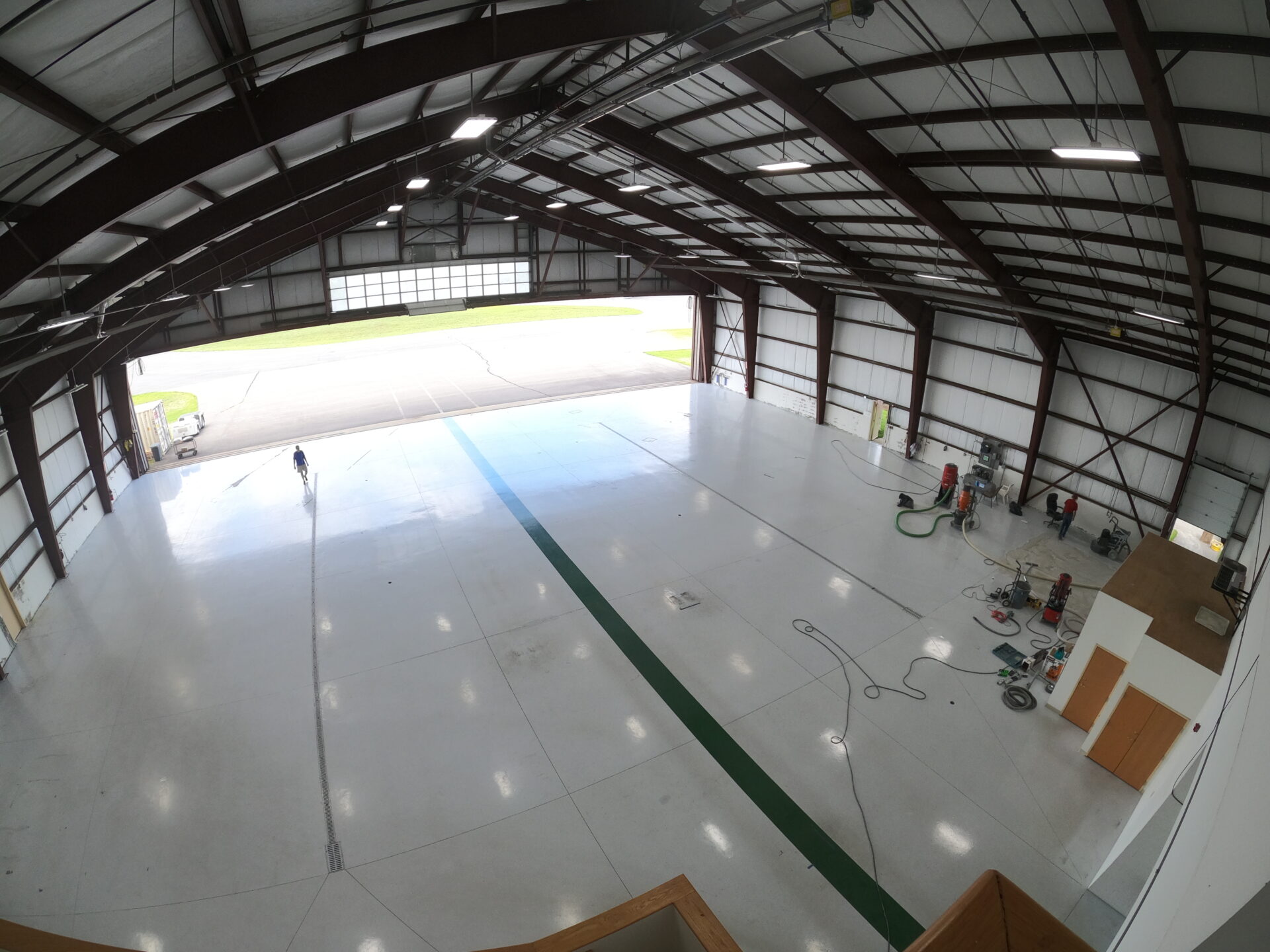 A before and after of an epoxy removal job in Nashua, New Hampshire in an aircraft hangar.