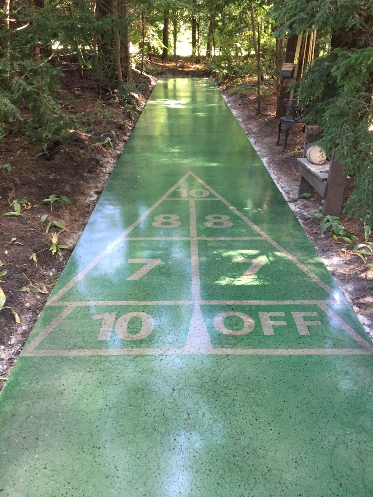 After several years of exposure to the weather and pine trees, this shuffleboard needed some attention. After grinding the court to clean concrete and starting the honing process, a stencil was placed on the slab and stain and densifier were applied. The court was polished to an 800 grit finish, and a guard was applied.