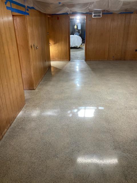 Basement job in Whitman, MA. The slab had some moisture issues because no vapor barrier was under the slab, and therefore the owner removed the VCT. We started by grinding off the residual adhesives. After grinding, the slab was honed and densified. The slab was polished to an 800 grit finish. A guard was applied and the slab was burnished. You may see "ghosting" in the polished concrete after the VCT had been removed.